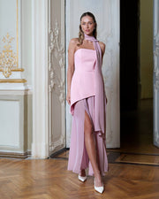Woman wearing a pink halter neck dress in an elegant interior setting