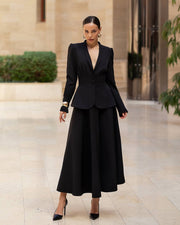 Woman wearing a black suit in an elegant indoor setting
