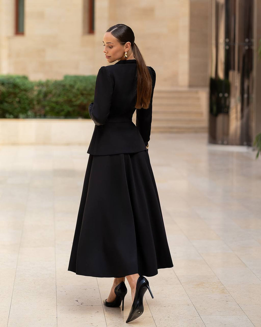 Woman in a black outfit walking on a stone pavement.