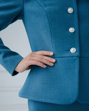 Close-up of a blue suit with buttons on a light gray background