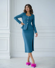 Woman wearing a blue suit with a white wall background