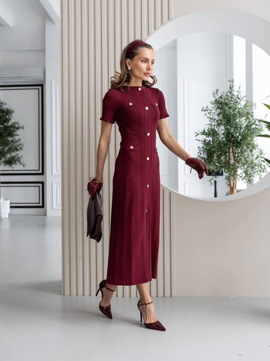 Woman in a burgundy dress standing in a modern interior setting