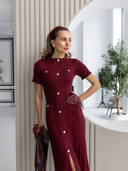 Woman wearing a burgundy dress with buttons in an indoor setting