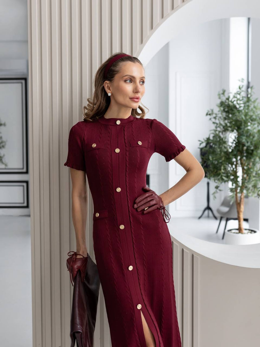 Woman wearing a burgundy dress with buttons in an indoor setting