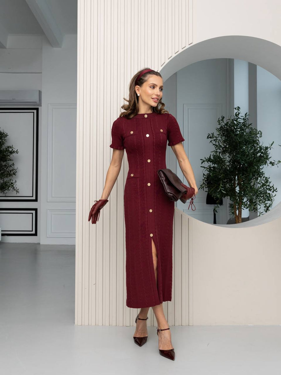 Woman in a burgundy dress standing in a modern interior setting