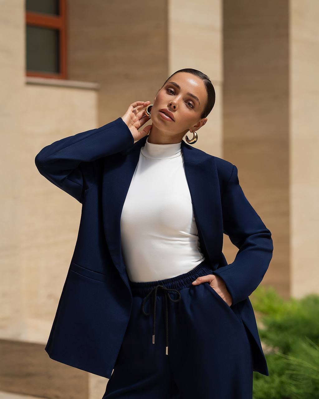 Woman wearing a navy blazer and white top outdoors