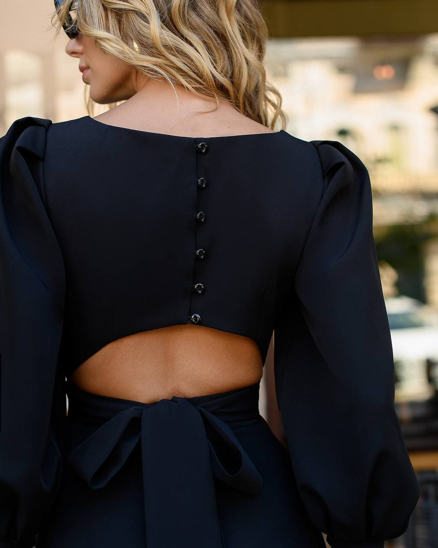 Black crop top with puffed sleeves and open back worn by a person outdoors.