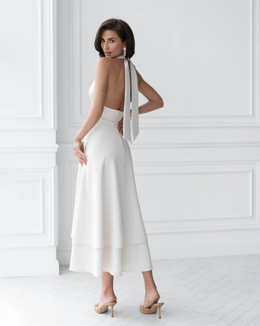 Woman wearing a white dress with thin straps in a minimalistic setting