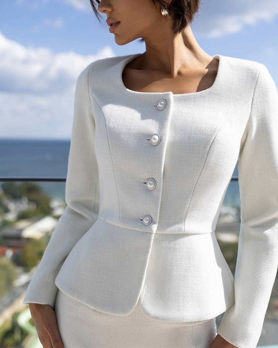 White blazer worn by a person with a scenic background