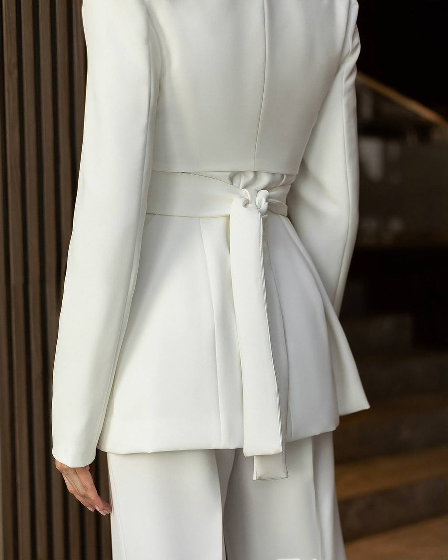 White suit with a tie detail on a blurred background