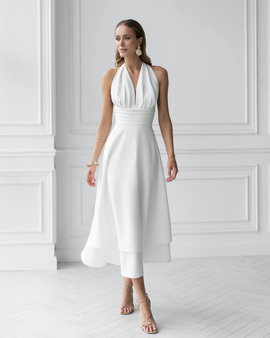 Woman wearing a white halter neck dress in a minimalistic setting